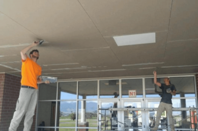 Screenshot-2026-04-30-145812.png Drywall contractor installing a suspended ceiling in a commercial building.